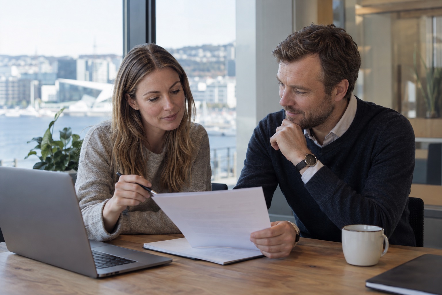 To kolleger gjennomgår en arbeidsavtale i Oslo. KI-generert illustrasjon.